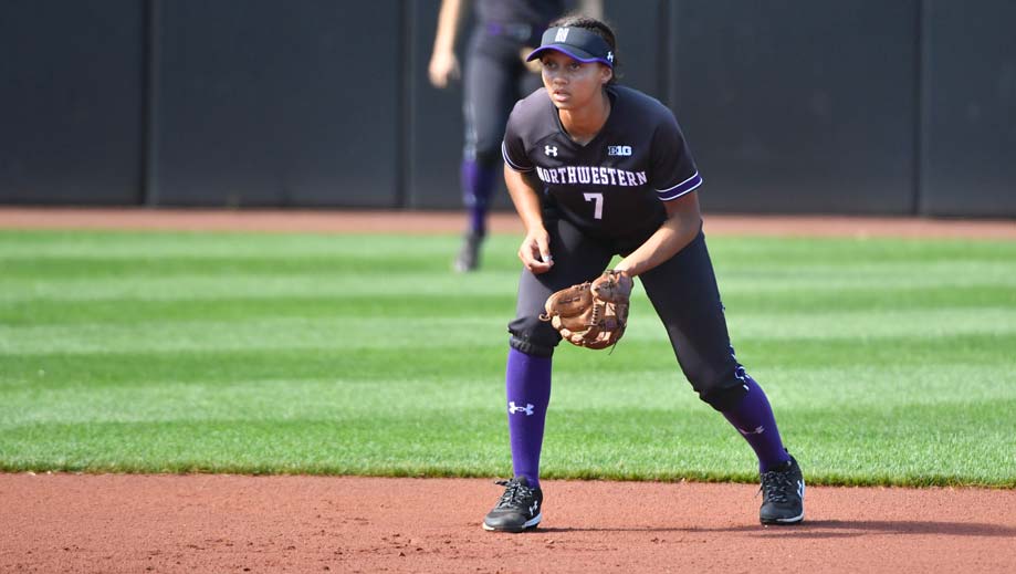 A softball player on the field with glove open
