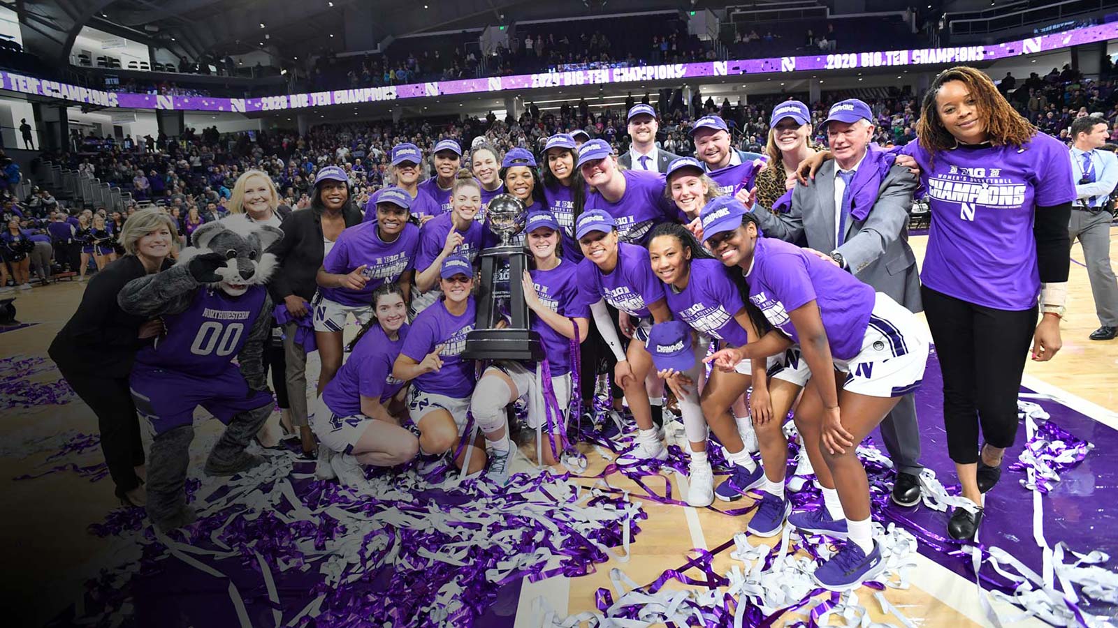 Women's basketball players holding a trophy on the court